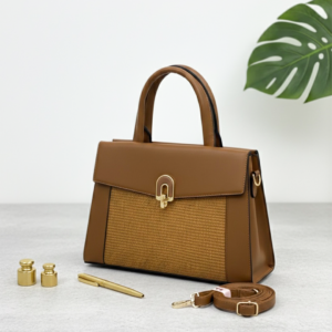 Elegant brown leather handbag with gold accents on modern desk - Earth