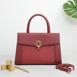 Elegant brown leather handbag with gold accents on modern desk - redwine