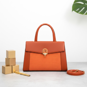 Elegant brown leather handbag with gold accents on modern desk - Sunset